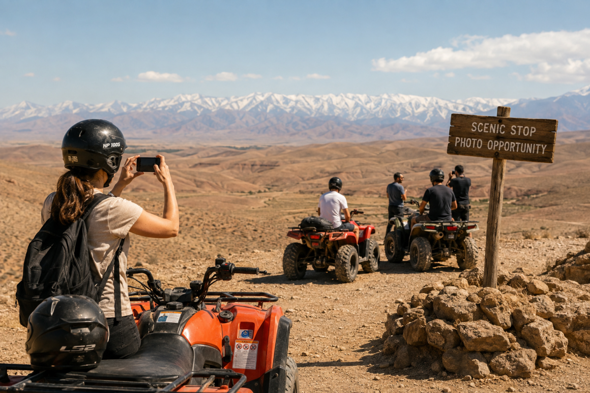 Travelers taking photos during a scenic stop in the Agafay Desert with views of the Atlas Mountains